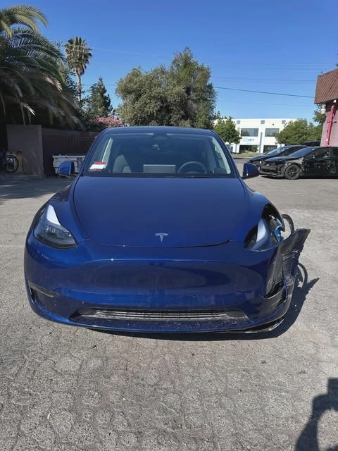 Blue Tesla Model Y with front-end collision damage